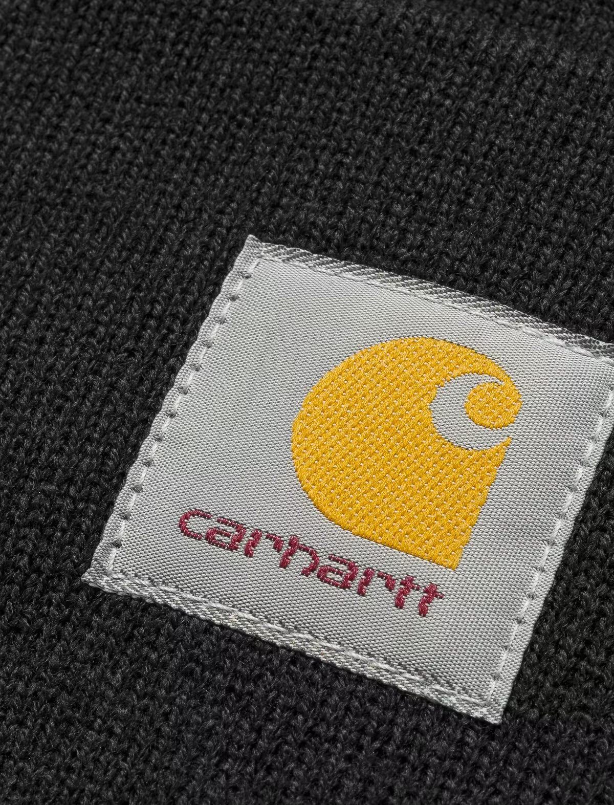 Carhartt logo tag on a black fabric background