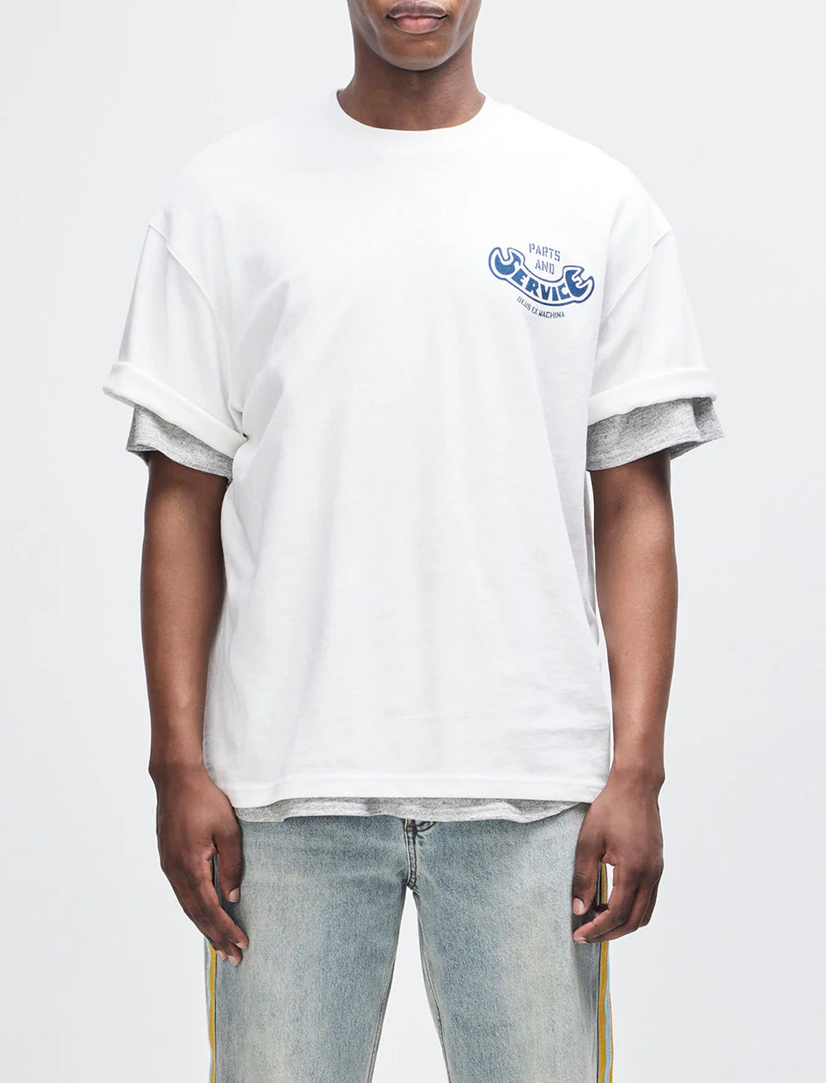 Person wearing a white t-shirt with a logo on a plain background