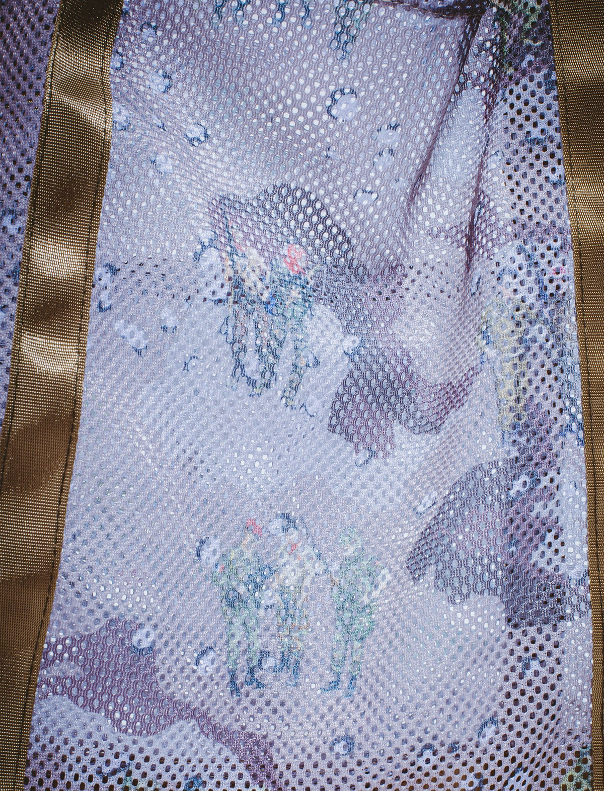 Close-up of a sequined fabric with a butterfly pattern on a mesh background.