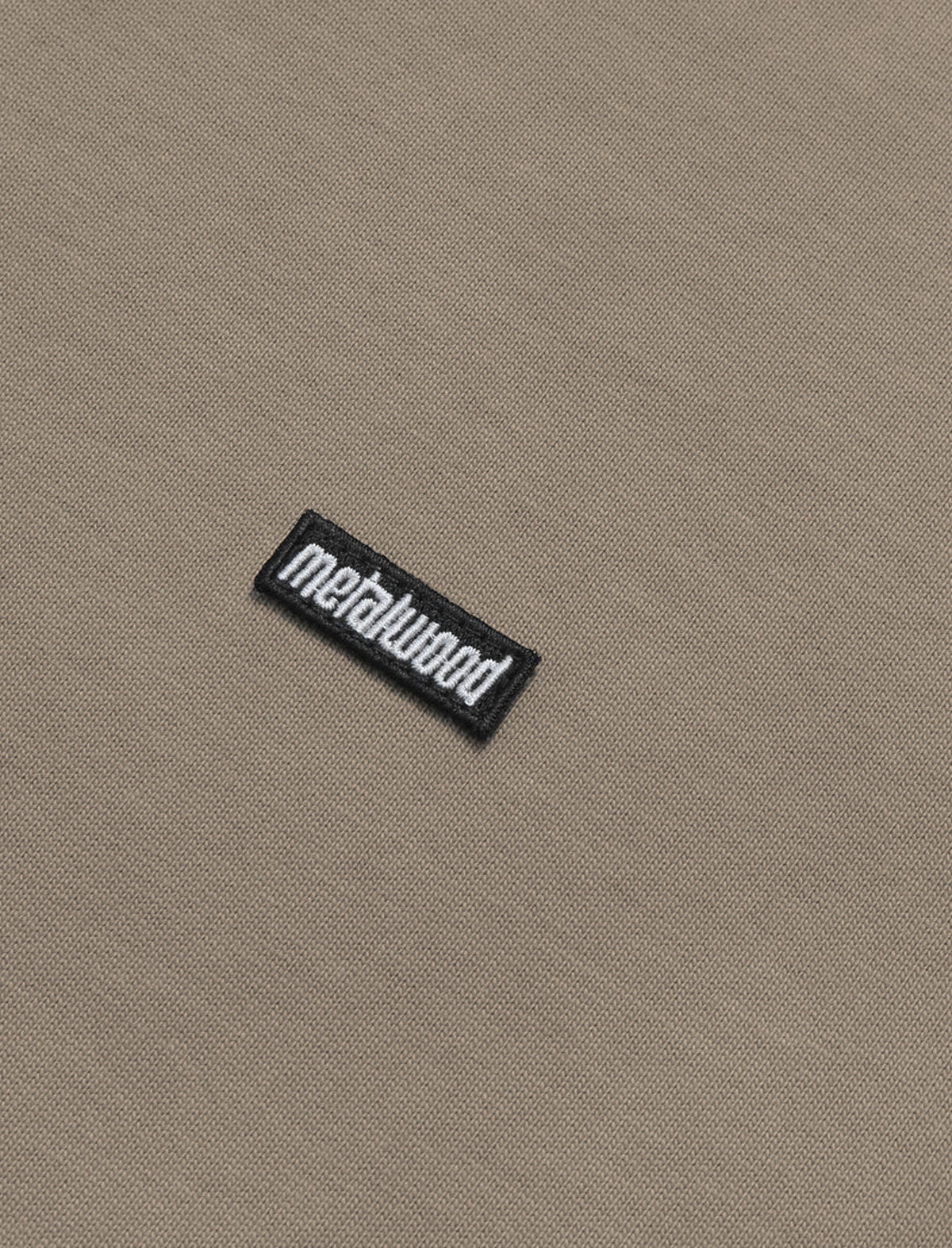 Close-up of a 'metalwood' logo on beige fabric