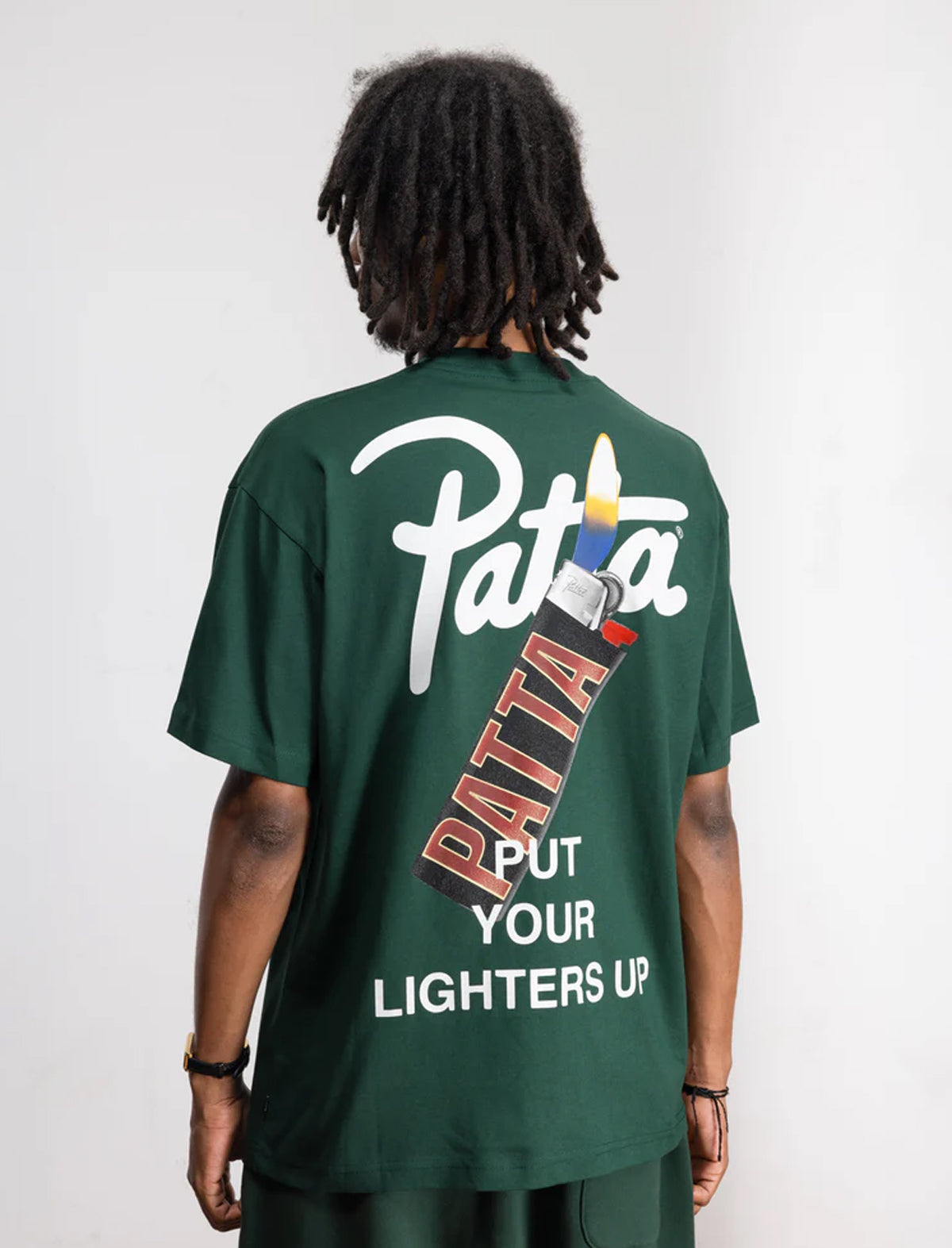 Person wearing a green t-shirt with 'Patta' branding on the back