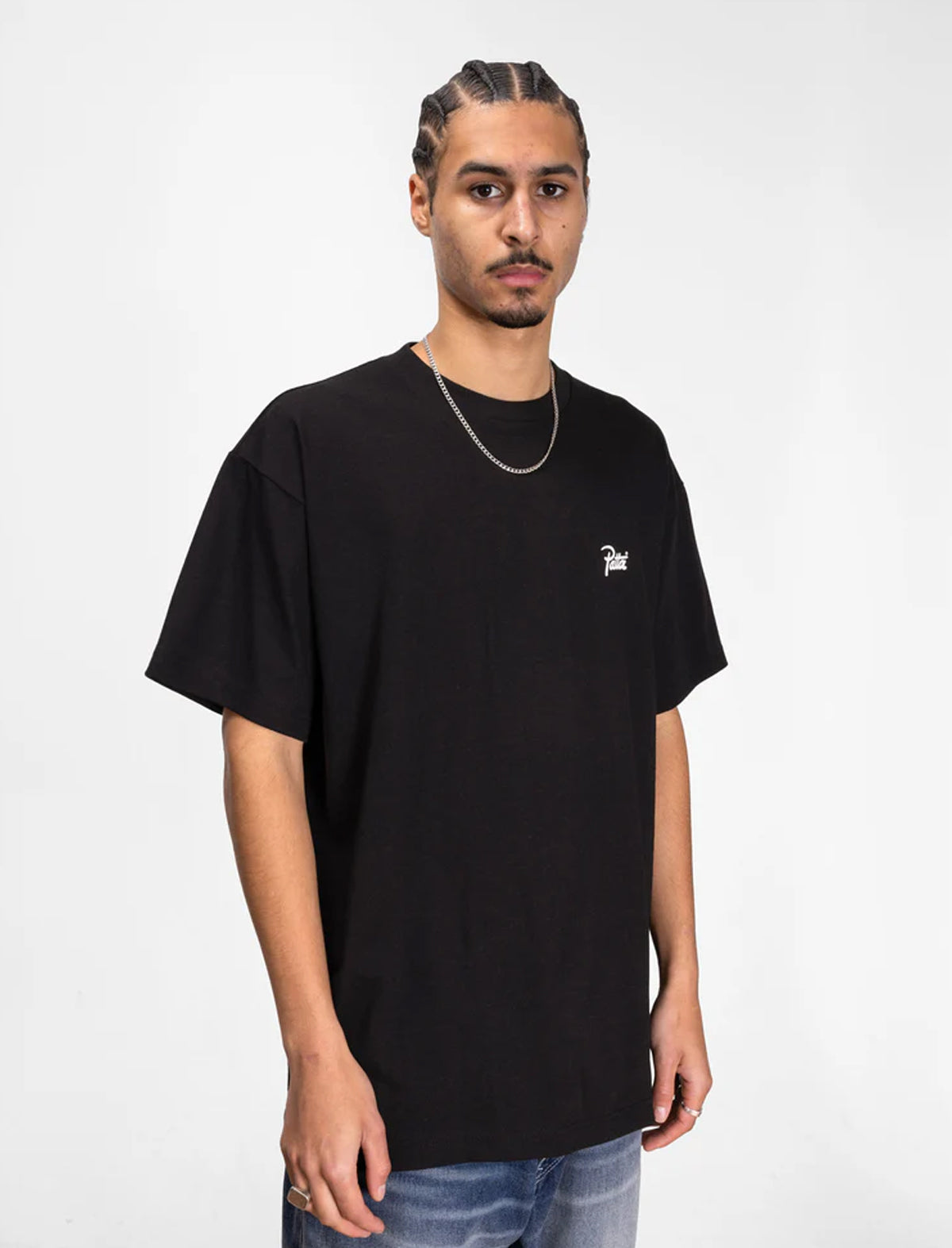 Man wearing a black t-shirt with a small logo on a white background