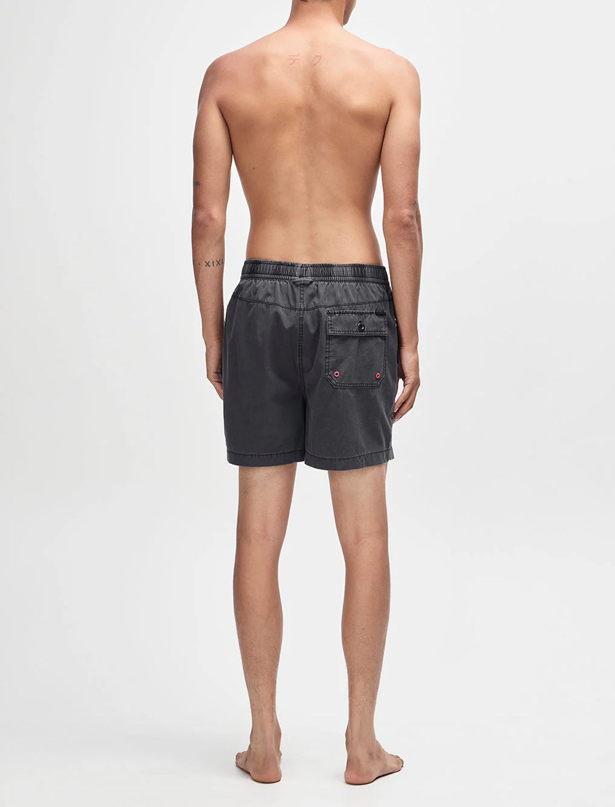 Person wearing black denim shorts on a white background