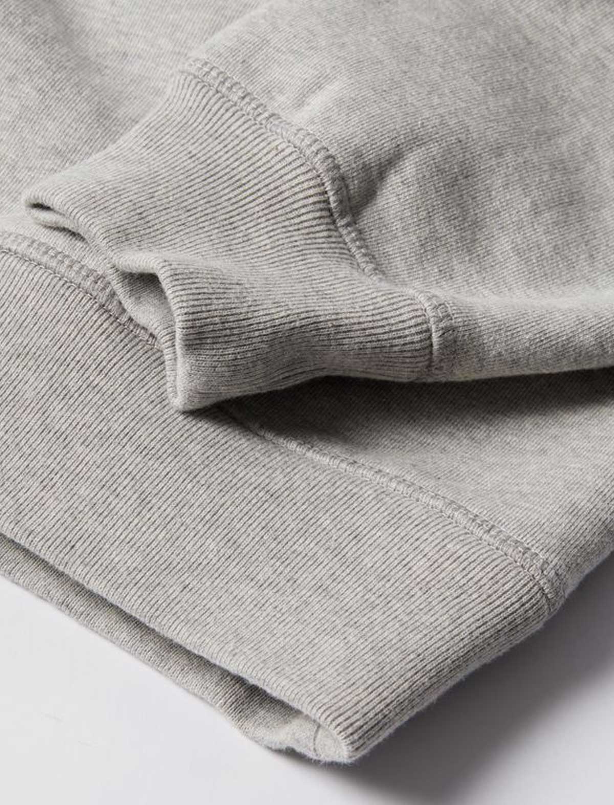 Close-up of a folded gray sweater on a light gray background