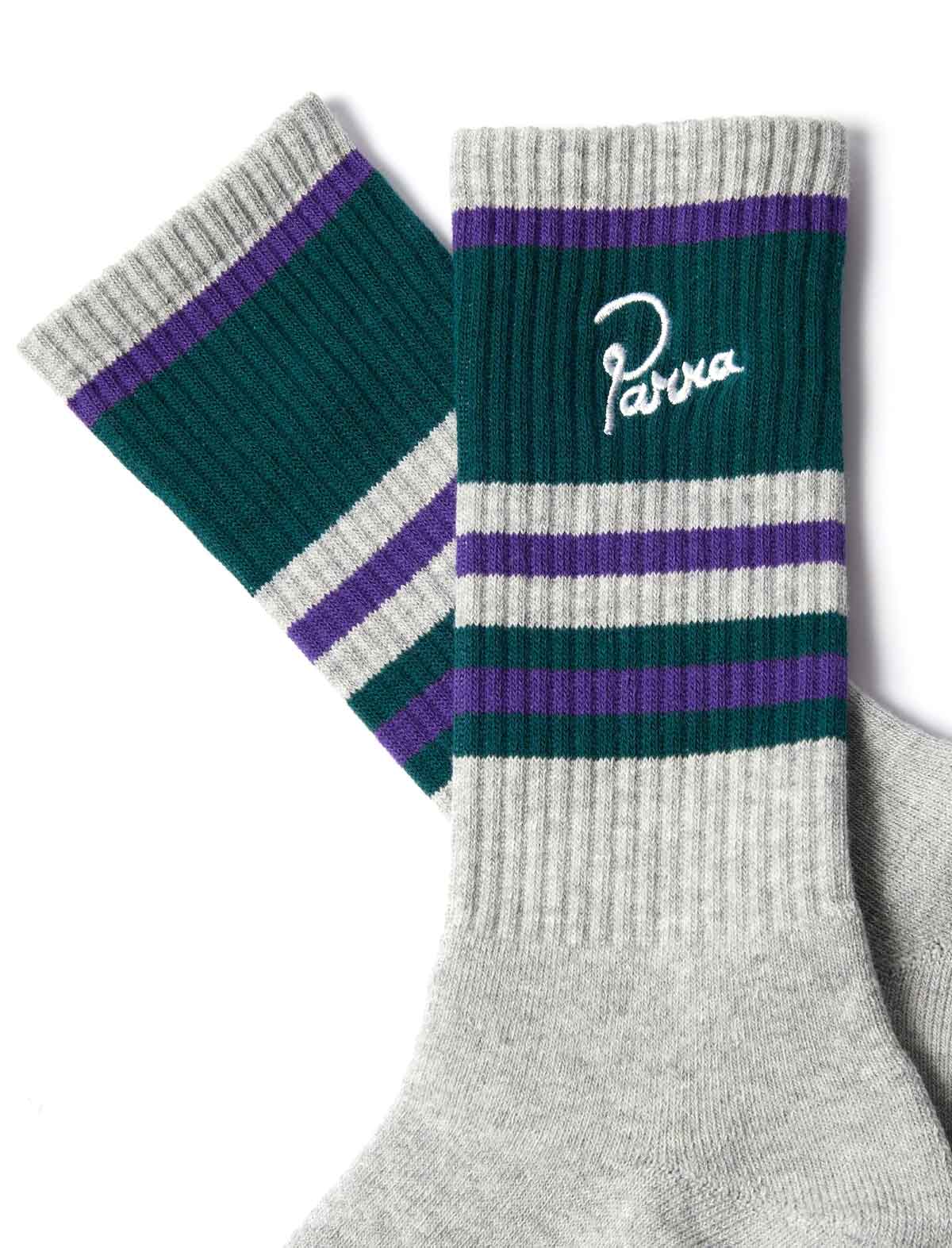 A pair of crew socks with a heather gray ribbed foot and cuff, featuring dark green and purple horizontal stripes near the top. One sock displays a white embroidered script logo reading 'Parva'.