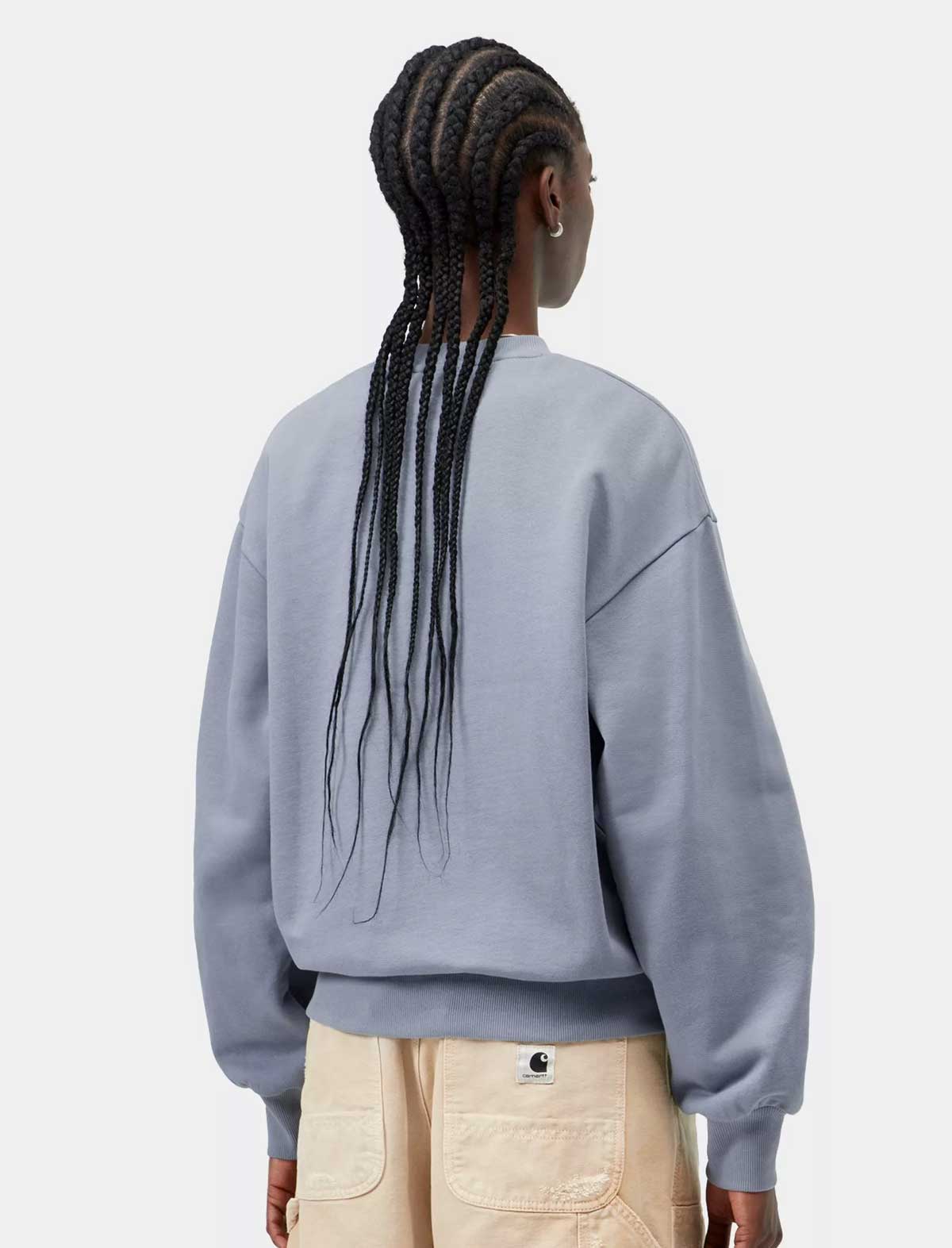 Person wearing a light gray sweatshirt with a visible brand logo on a white background