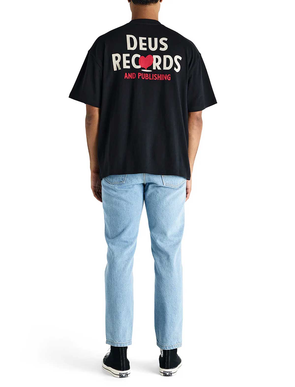 Person wearing a deus ex machina deep cut black t-shirt with 'Deus Records' text on the back, standing against a white background.