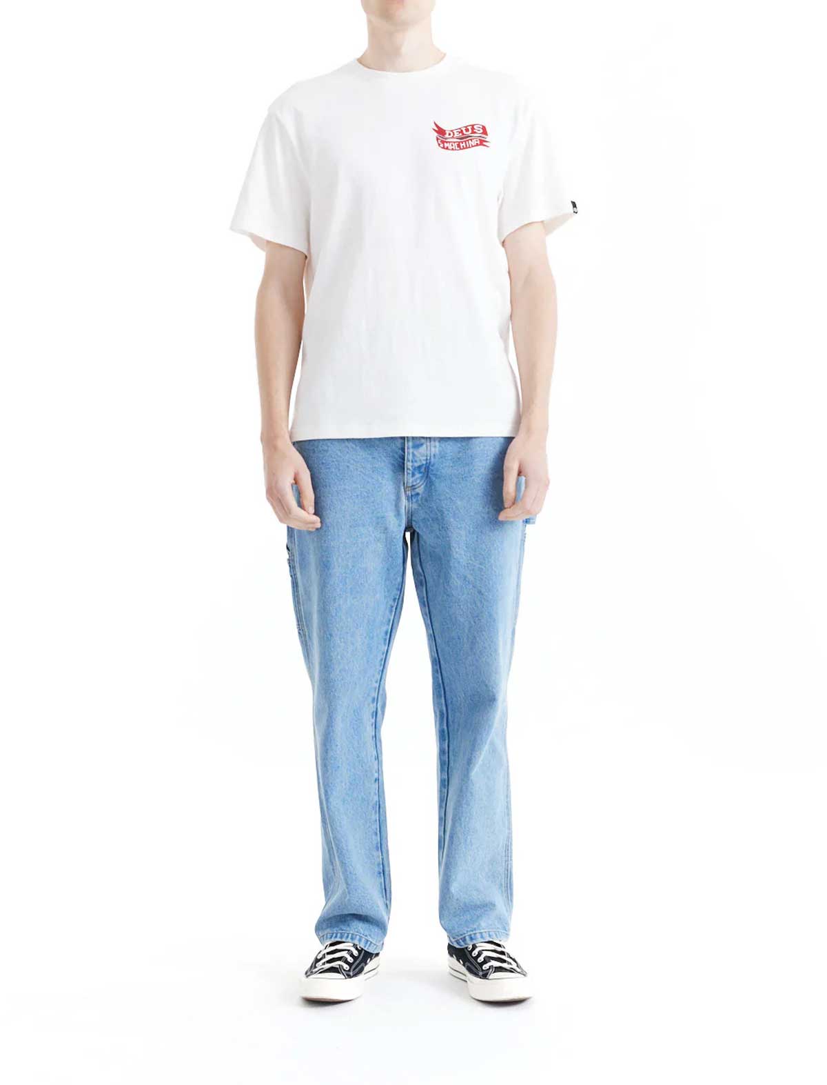 Person wearing a deus ex machina jailer sappy white t-shirt with a red logo and blue jeans on a white background