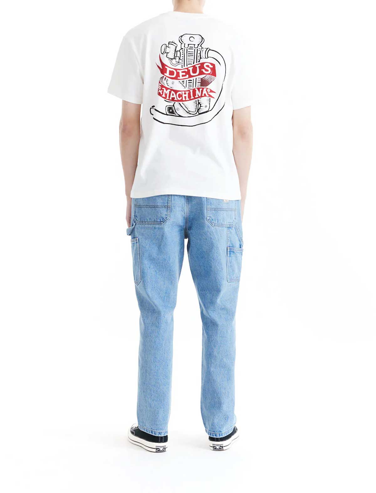 Person wearing a deus ex machina jailer sappy white t-shirt with a logo and light blue jeans on a white background