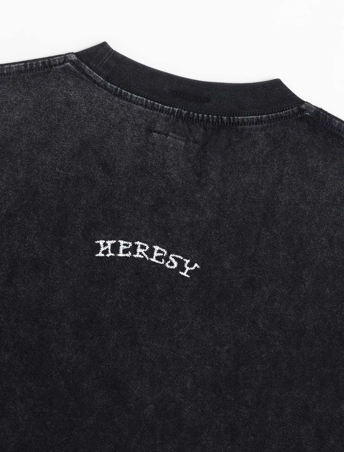 heresy embroidered logo on black tshirt on a white background