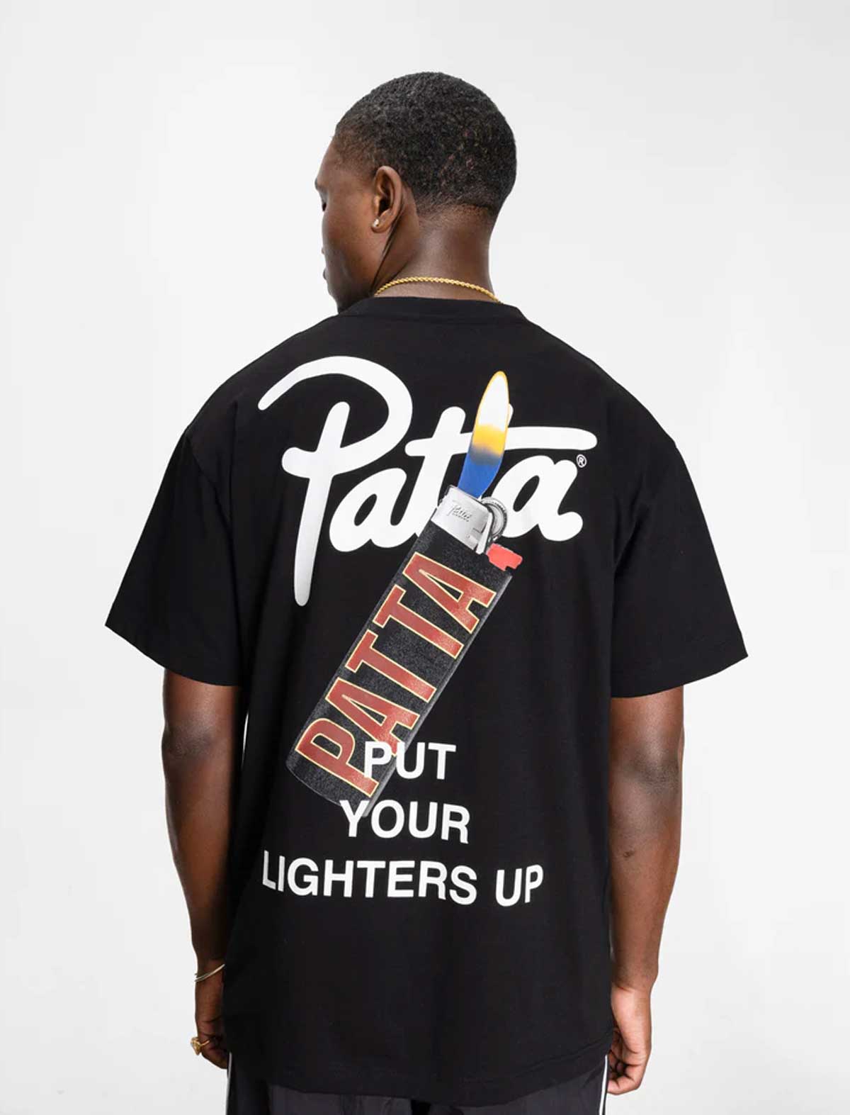 Person wearing a black t-shirt with 'Patta' branding on the back