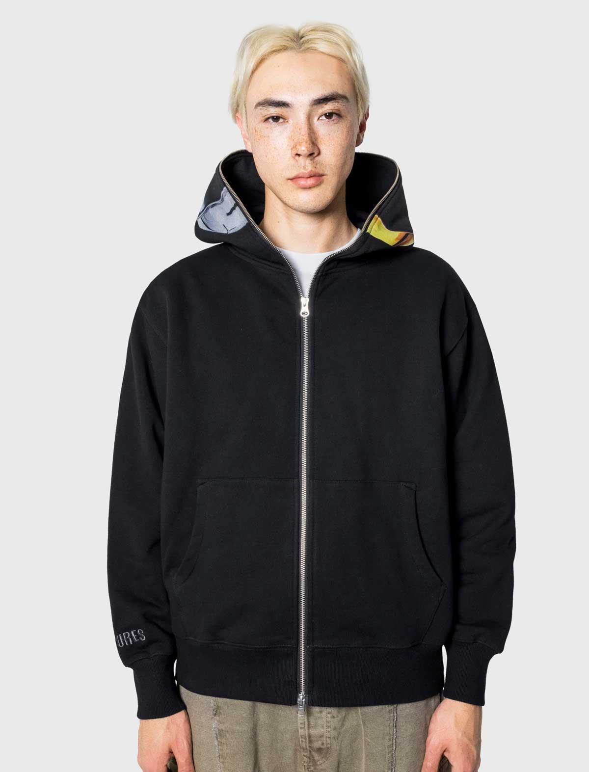 Person wearing a black hoodie with a gray hood against a white background
