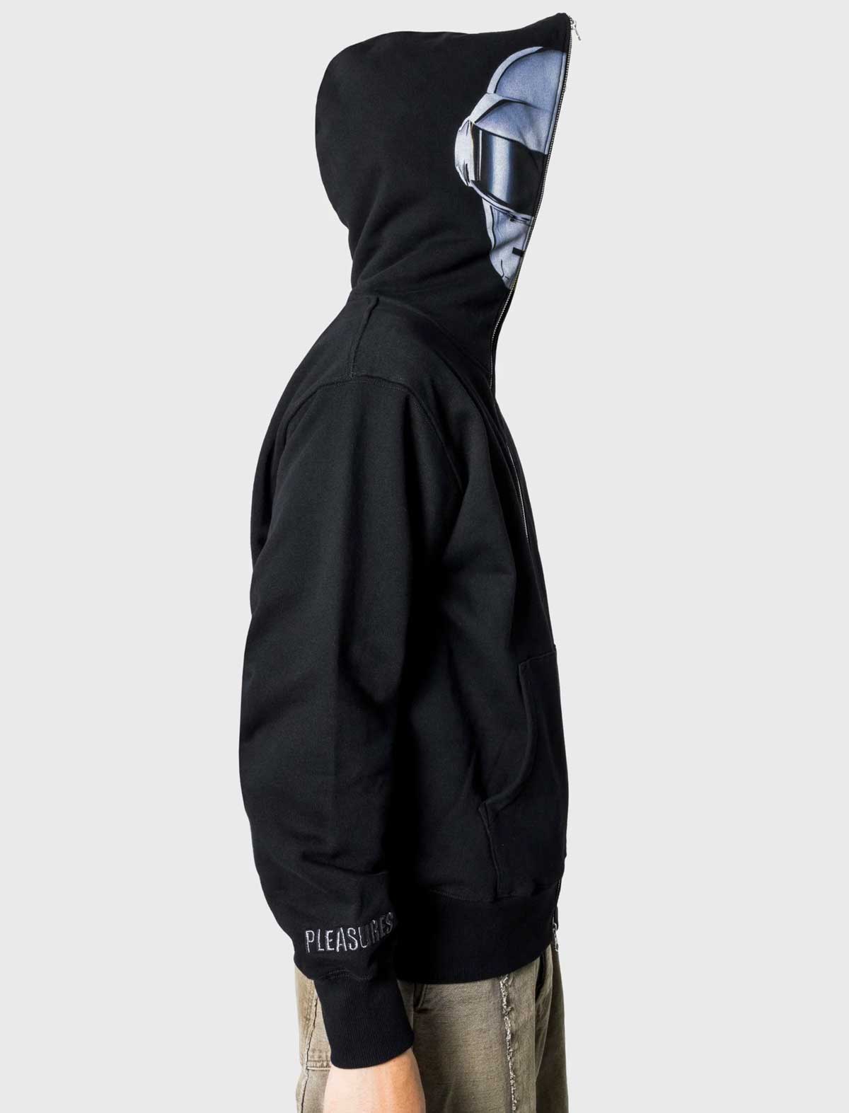 Person wearing a black hoodie with a unique design on the hood against a plain background