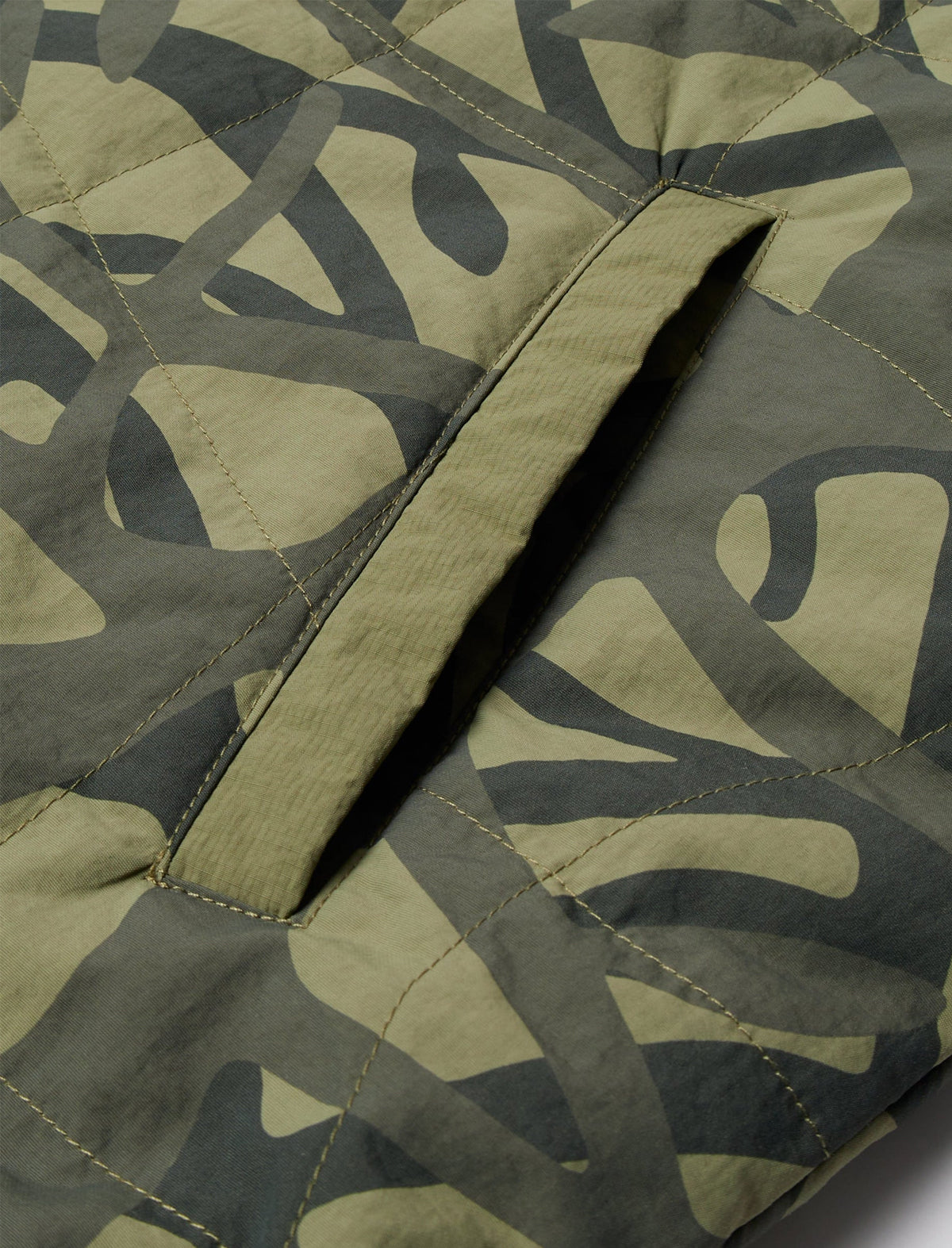 Close-up of a camouflage-patterned fabric with a visible seam.