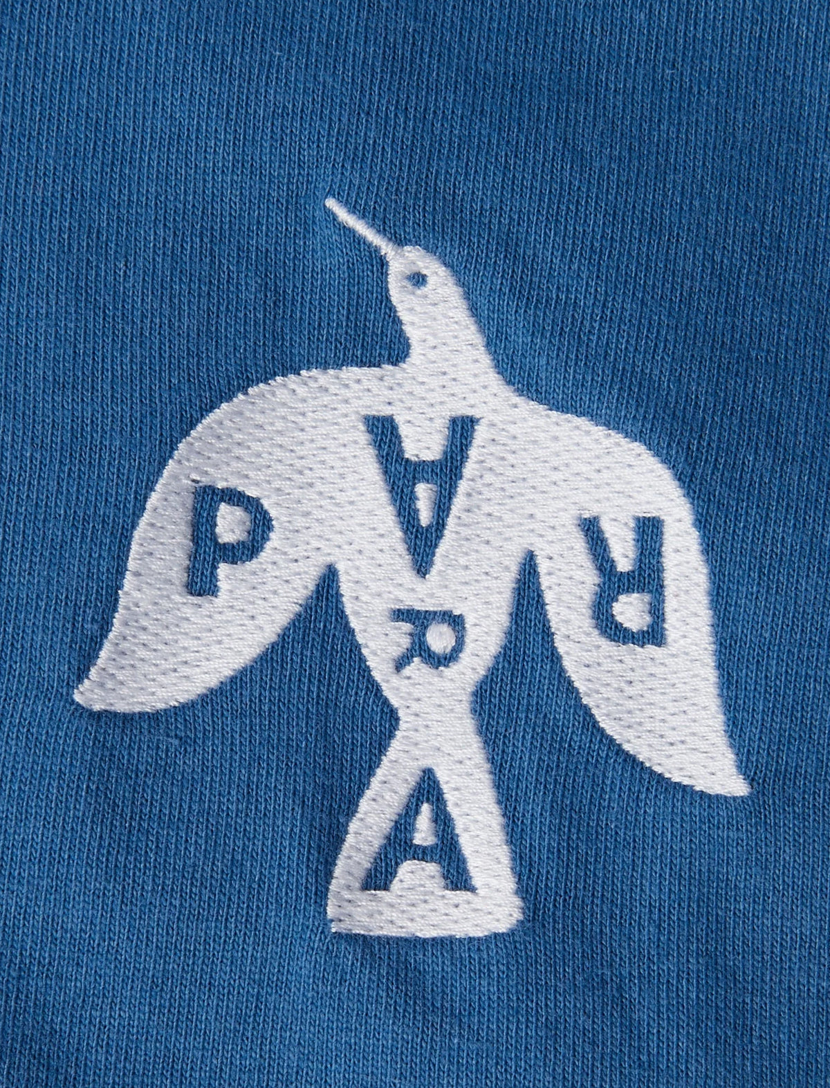 Embroidered logo on a blue fabric with 'PVR' letters