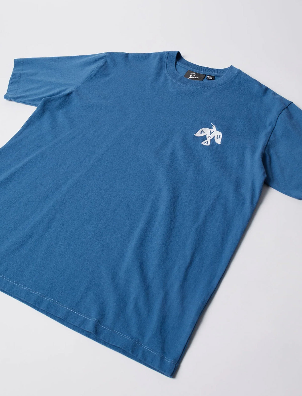 Blue t-shirt with a white logo on a light gray background