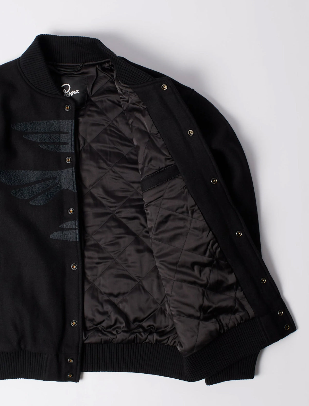Black varsity jacket with quilted design on a white background