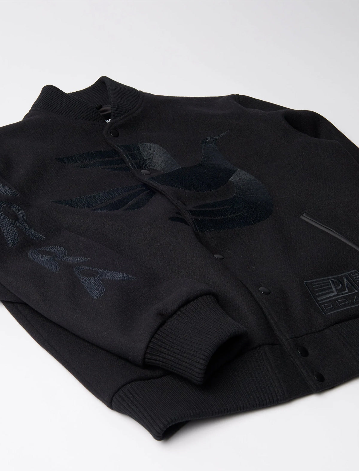 Folded black jacket with brand logo on a white background