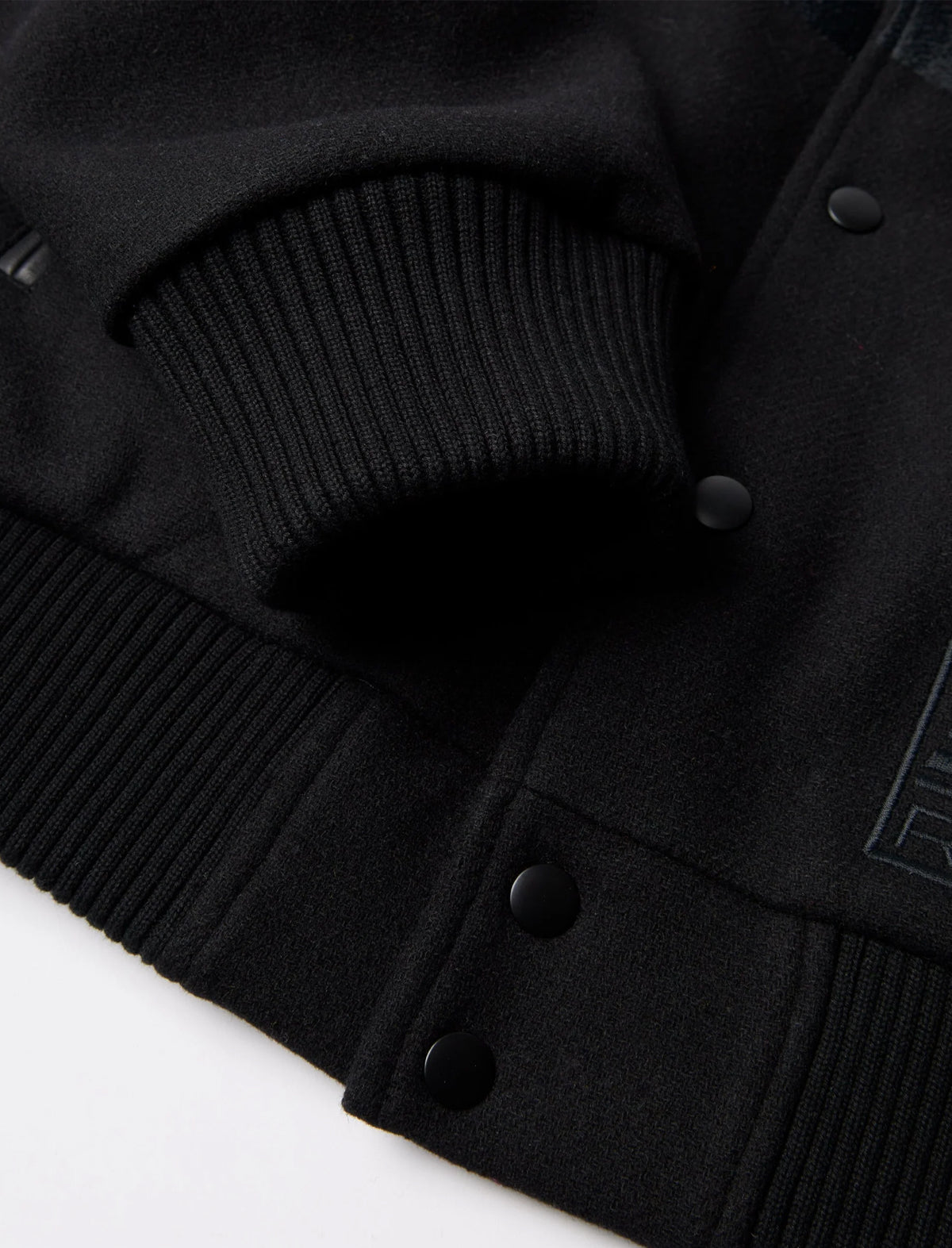 Close-up of a black coat with buttons on a white background