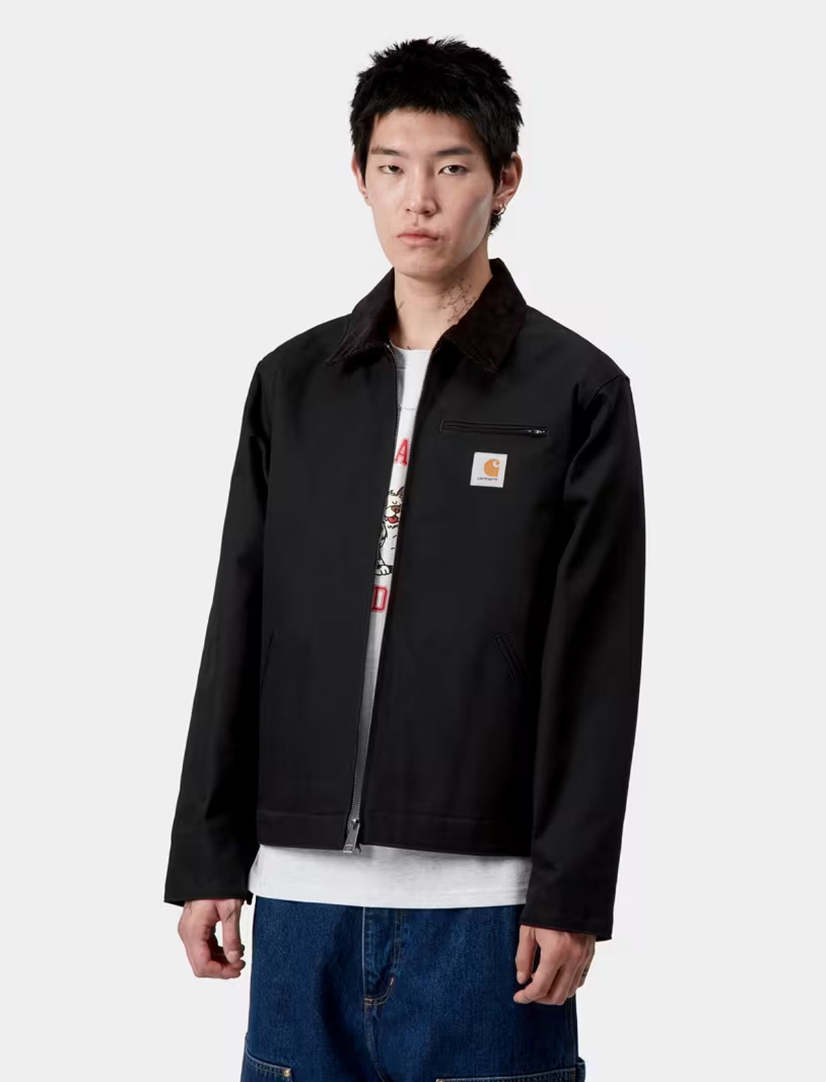 Person wearing a carhartt detroit black jacket with a visible brand logo on a white background