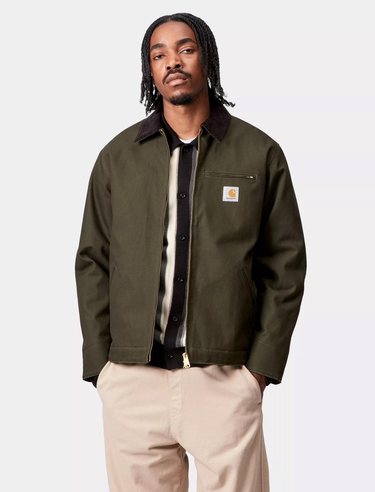Man wearing a Carhartt WIP Detroit green jacket with a brand logo on a white background