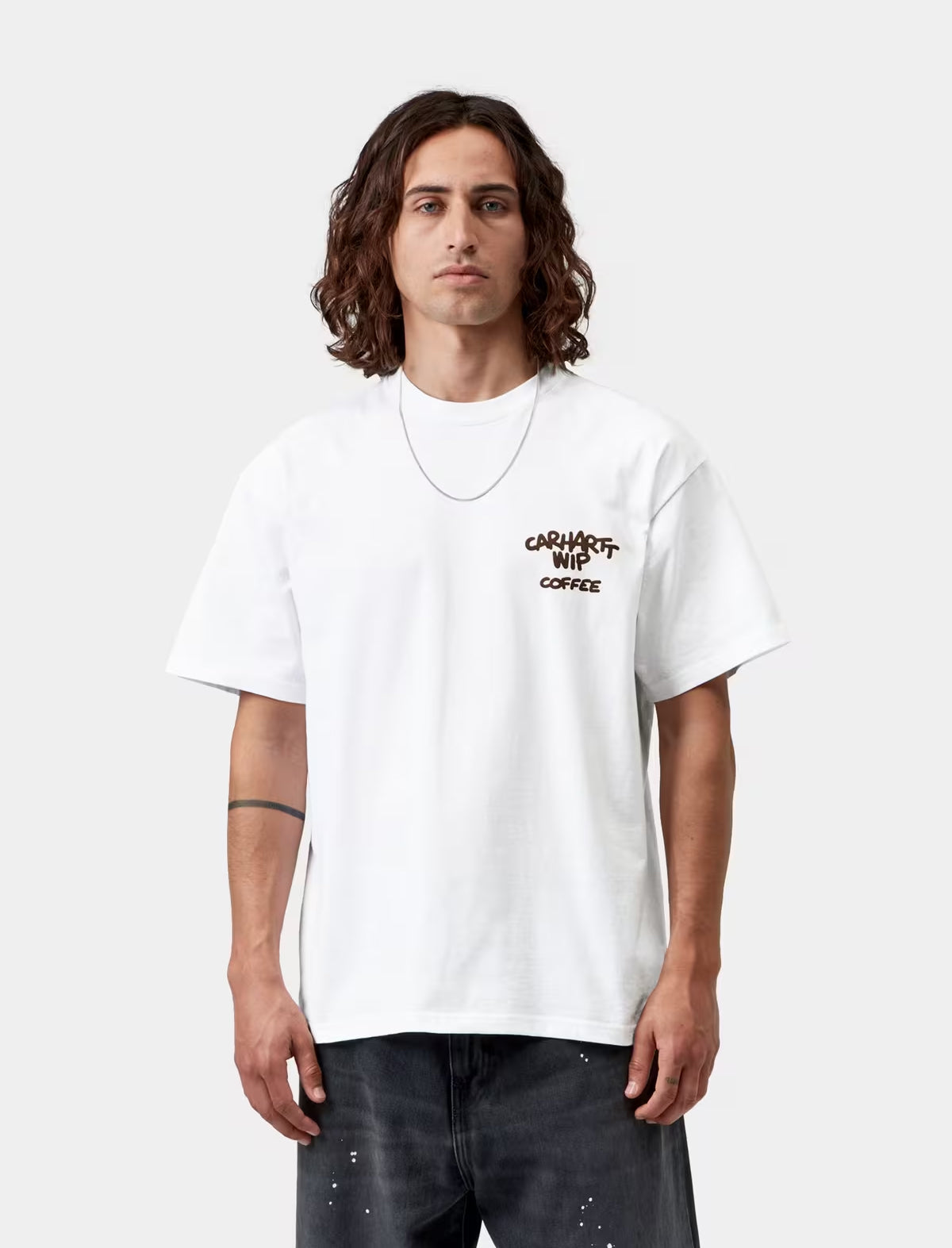 Person wearing a white t-shirt with text on a plain background