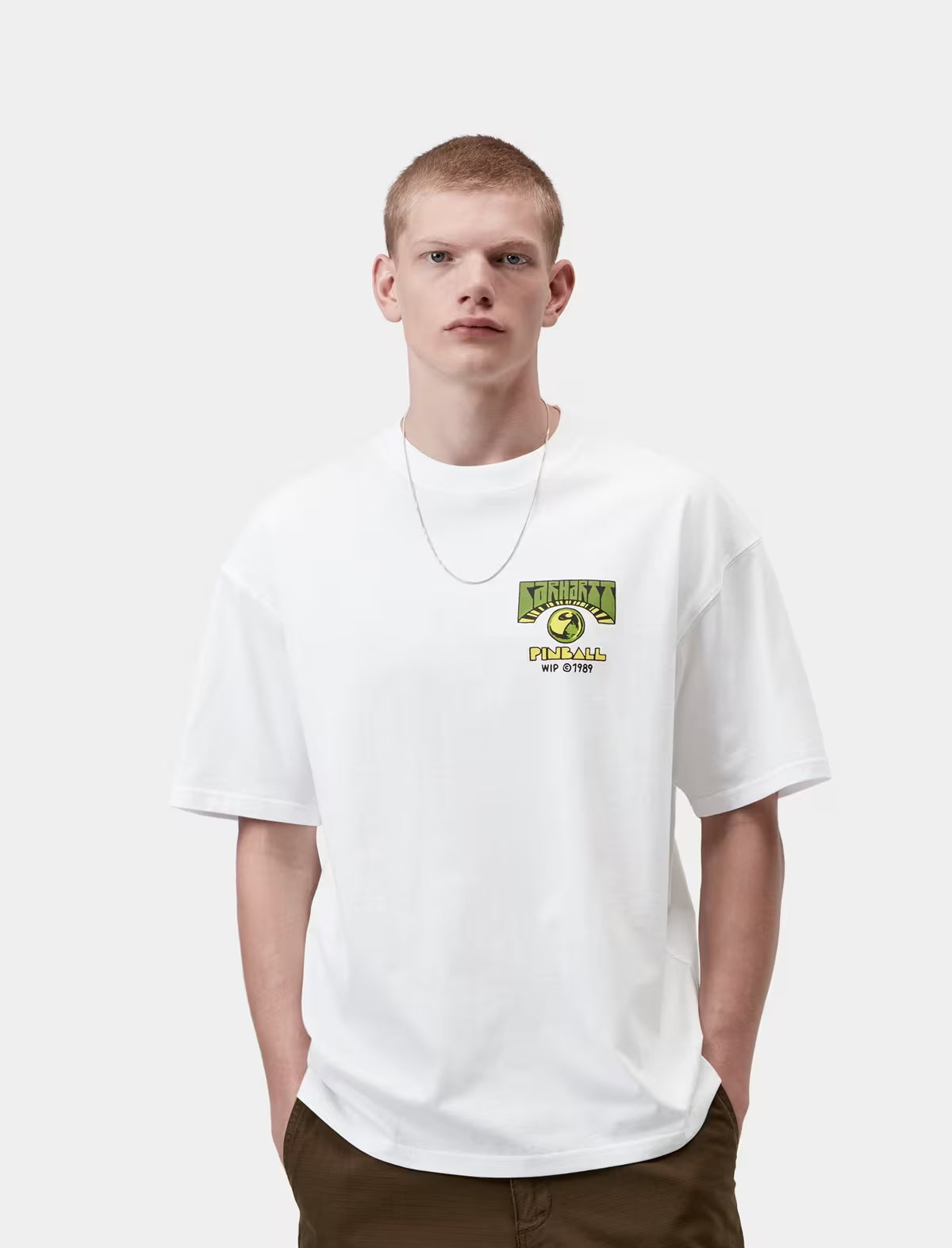 Person wearing a white t-shirt with a logo on a plain background