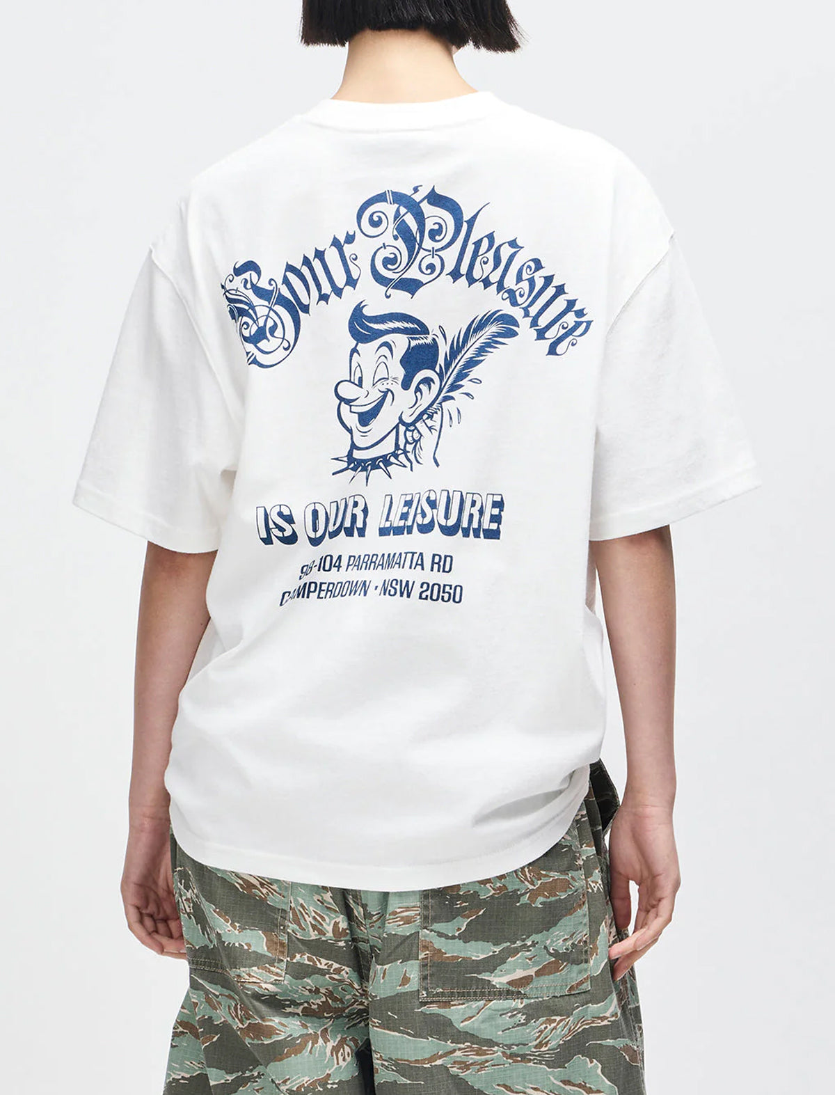 Person wearing a white t-shirt with blue graphics and text on a plain background