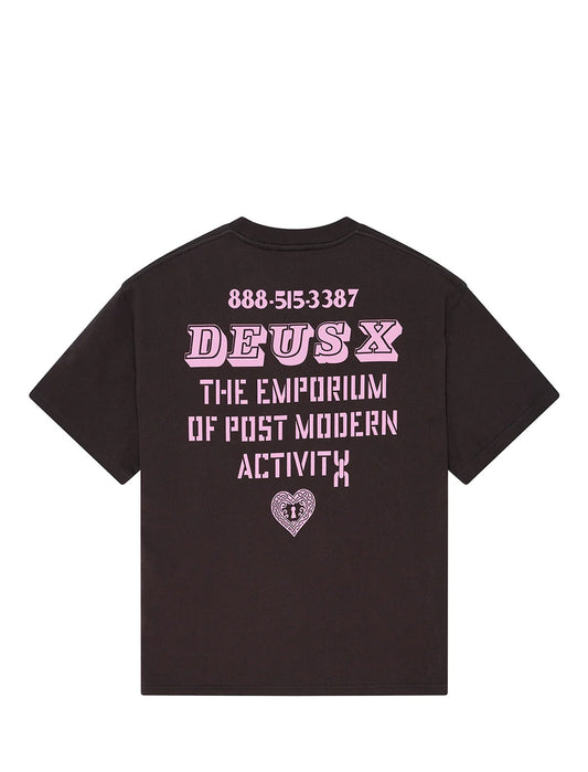 A black short-sleeve t-shirt shown from the back, featuring a pink graphic print with the text 'DEUS X THE EMPORIUM OF POST MODERN ACTIVITY' and a heart logo on a plain white background.