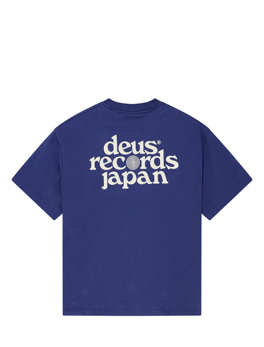 A royal blue short-sleeve t-shirt with 'deus records japan' printed in white across the chest, shown against a plain white background.