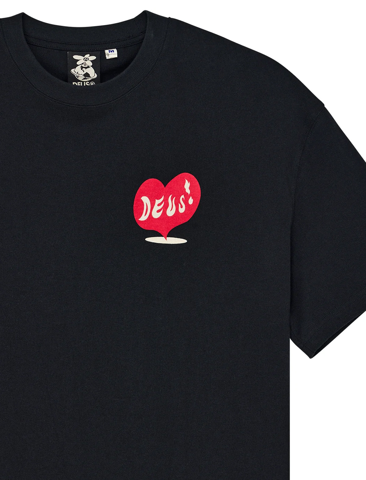 A close-up of a black crewneck t-shirt featuring a red heart-shaped balloon graphic on the left chest with the word 'DEUS' written in white script.