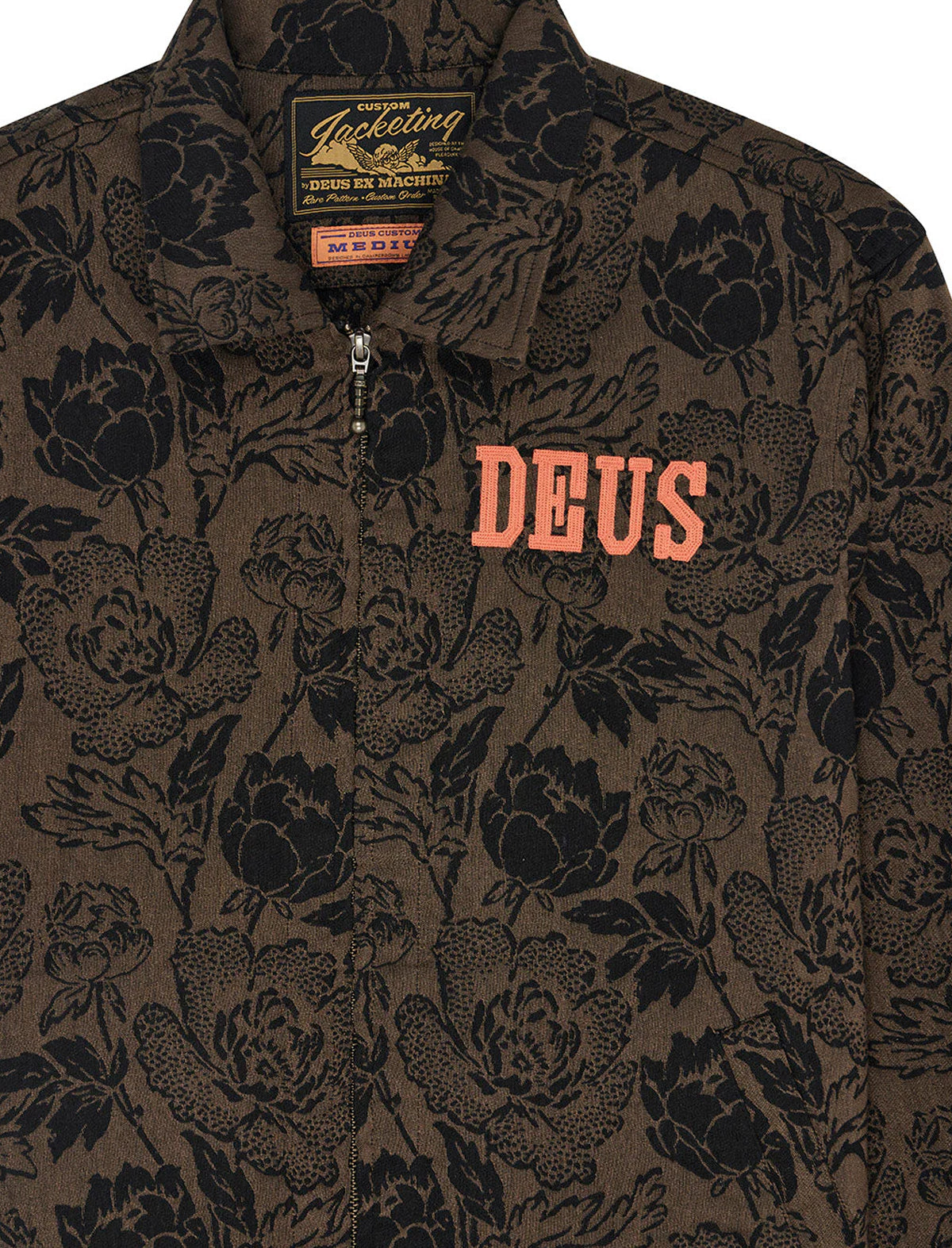 Floral patterned jacket with 'DEUS' branding on a dark background