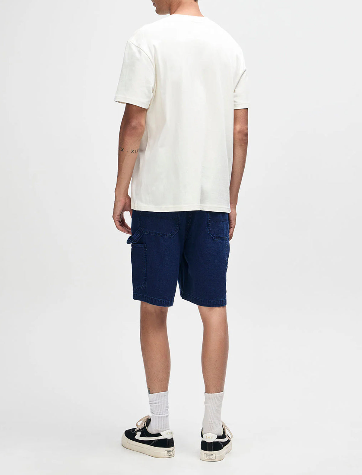 Person wearing a white t-shirt and navy shorts on a white background
