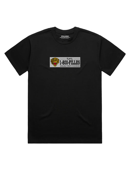 A black t-shirt with a bumper-sticker-style graphic across the chest featuring a tiger head illustration and the text 'Call Now, 1-800-FILLES, Available Twenty-Four/Seven', styled like a vintage vanity plate.