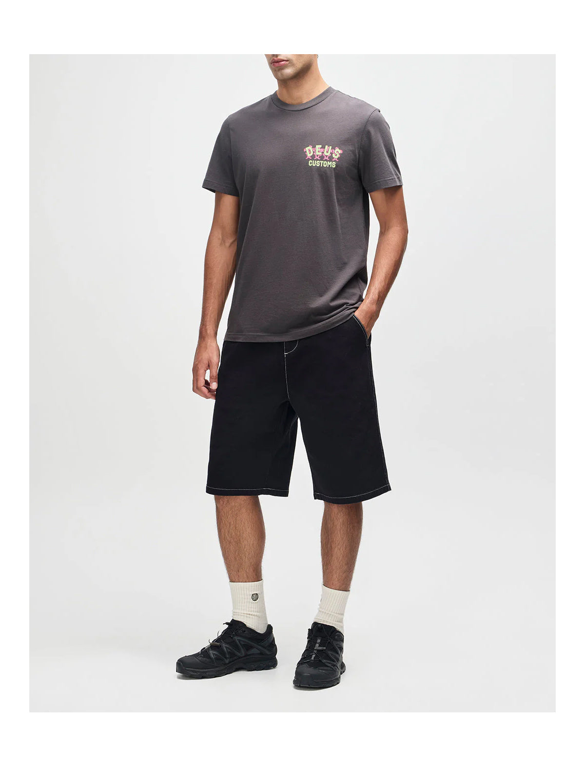 Person wearing a dark gray t-shirt and black shorts on a white background