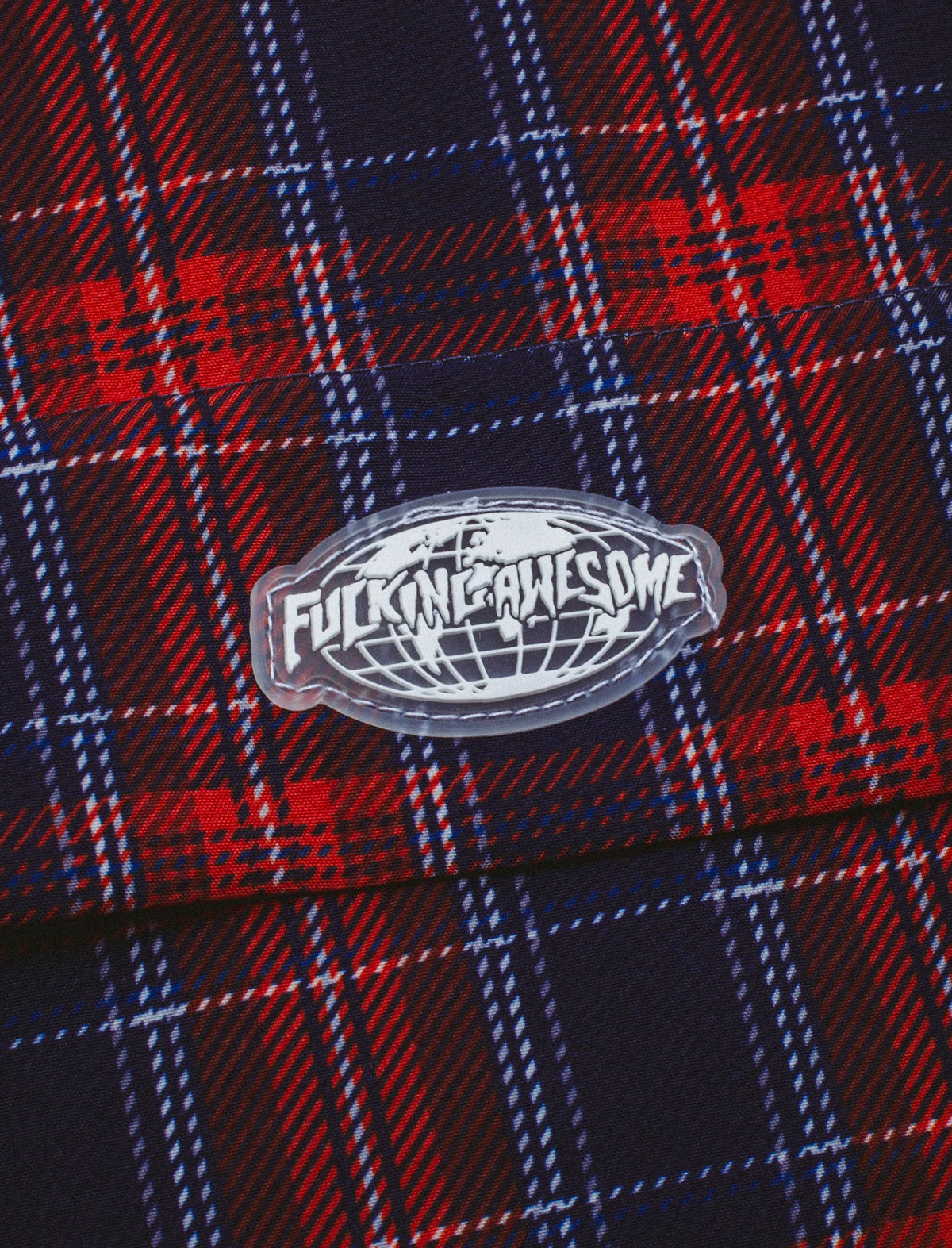 Close-up of a plaid fabric with a logo in the center