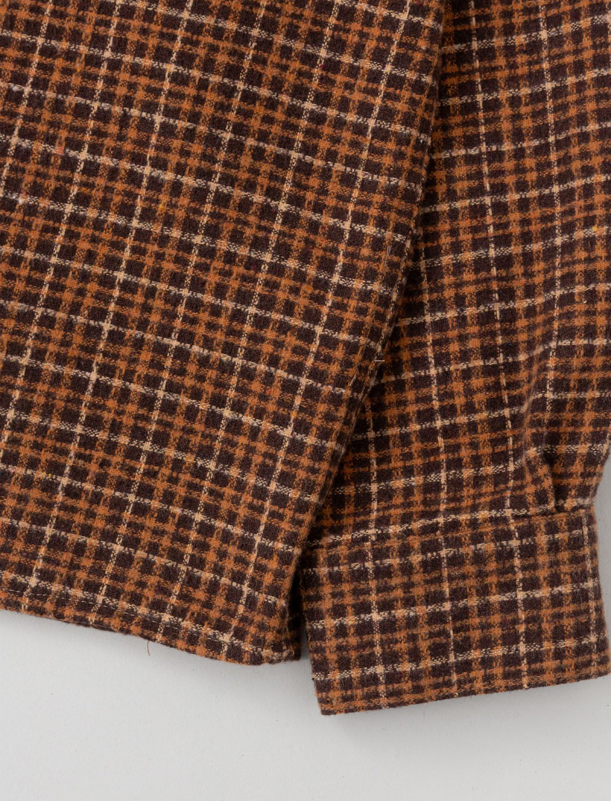 Close-up of Heresy Deft brown and beige checkered fabric on a white background