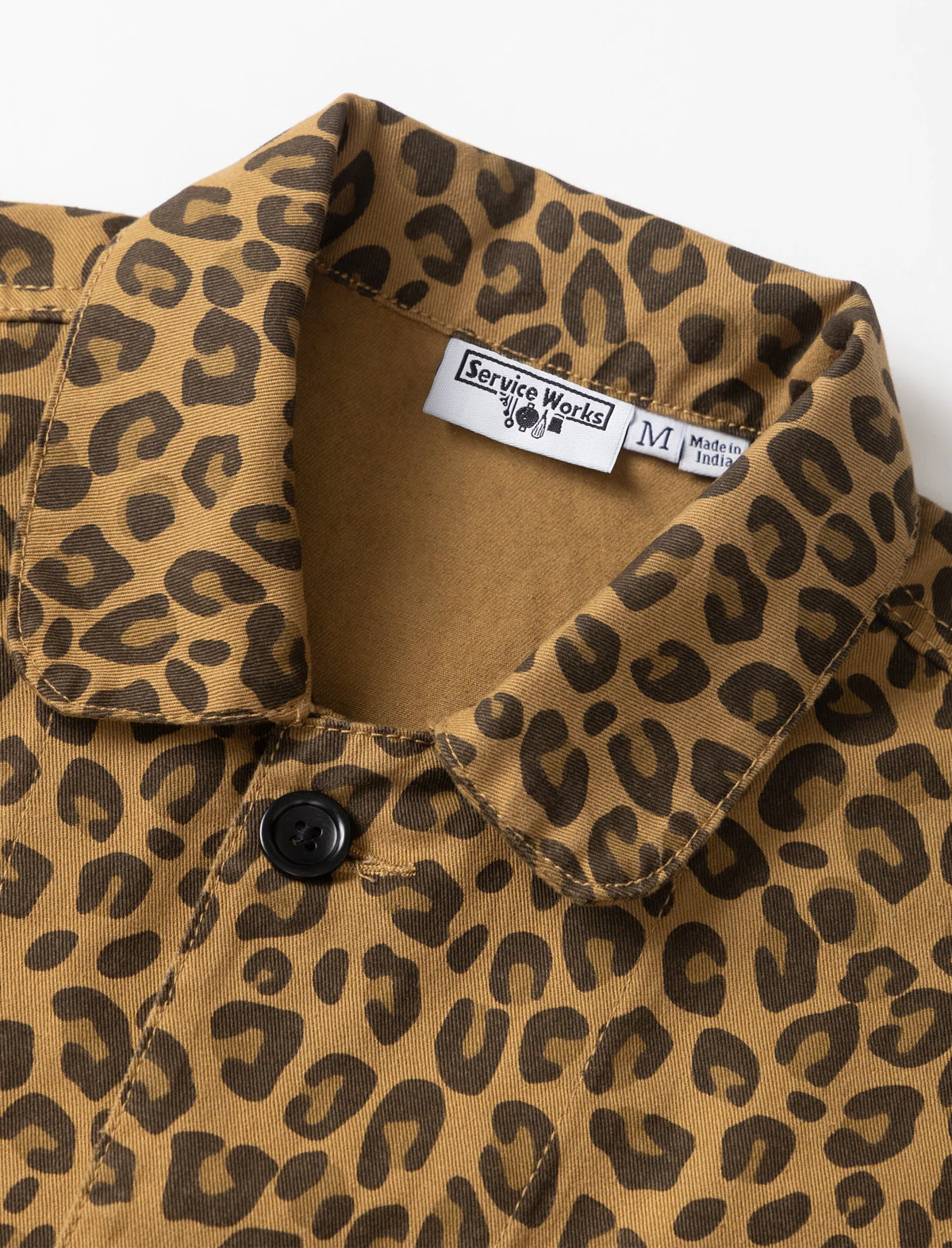 Close-up of a leopard print button-down shirt collar with a visible Service Works label.