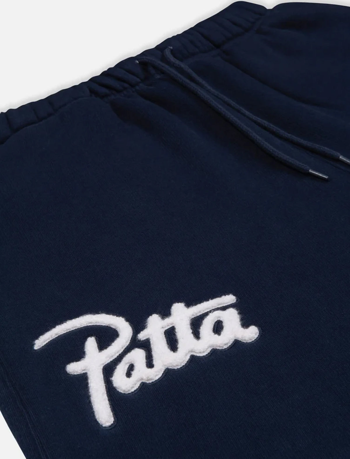Navy blue sweatpants with white 'Patta' logo on a white background
