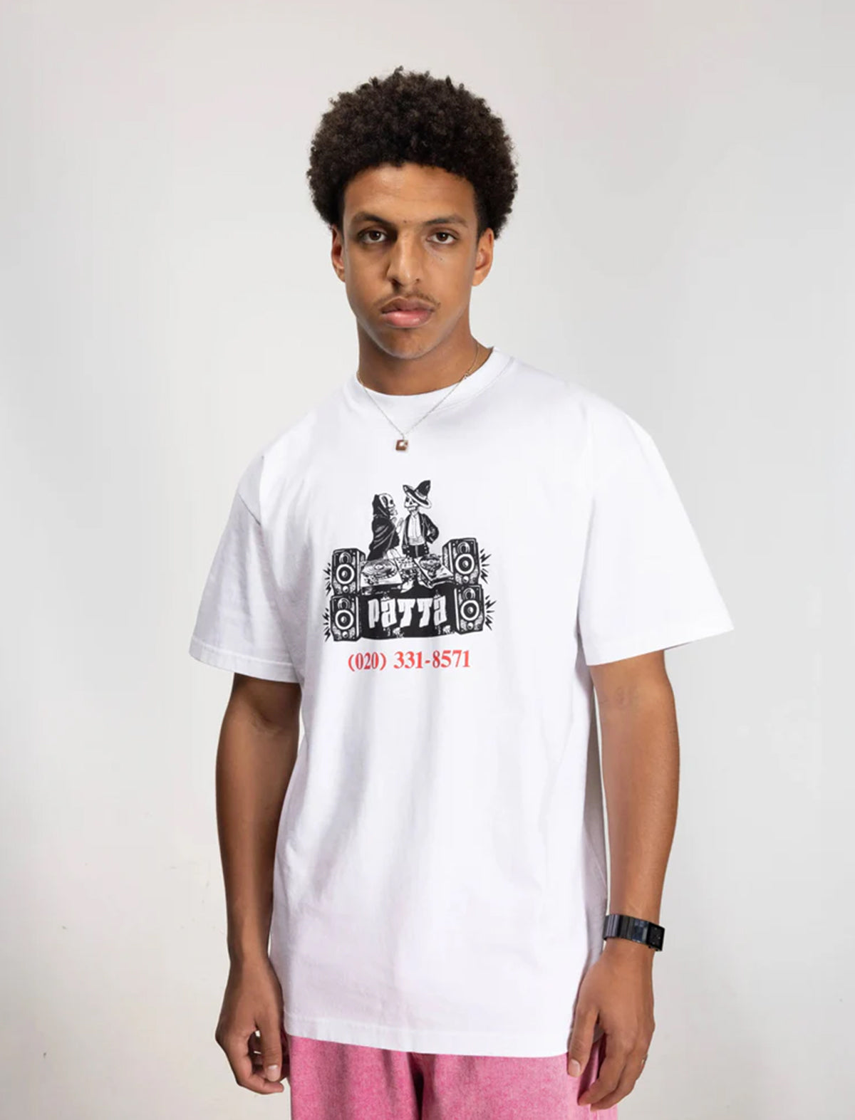 Person wearing a white t-shirt with a graphic design on a plain background