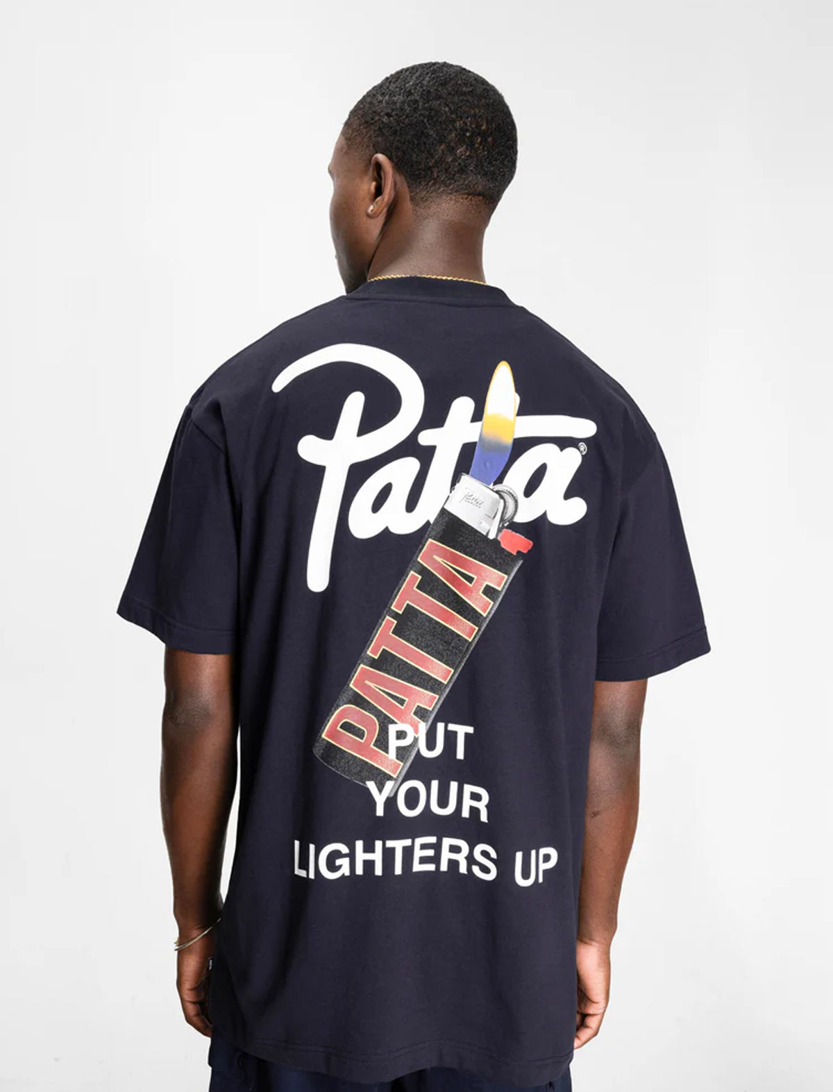 Person wearing a navy blue t-shirt with 'Patta' branding on the back.