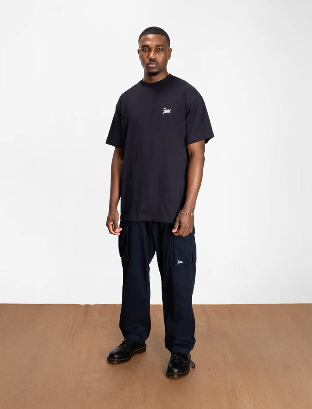 Man wearing a black t-shirt and pants on a white background
