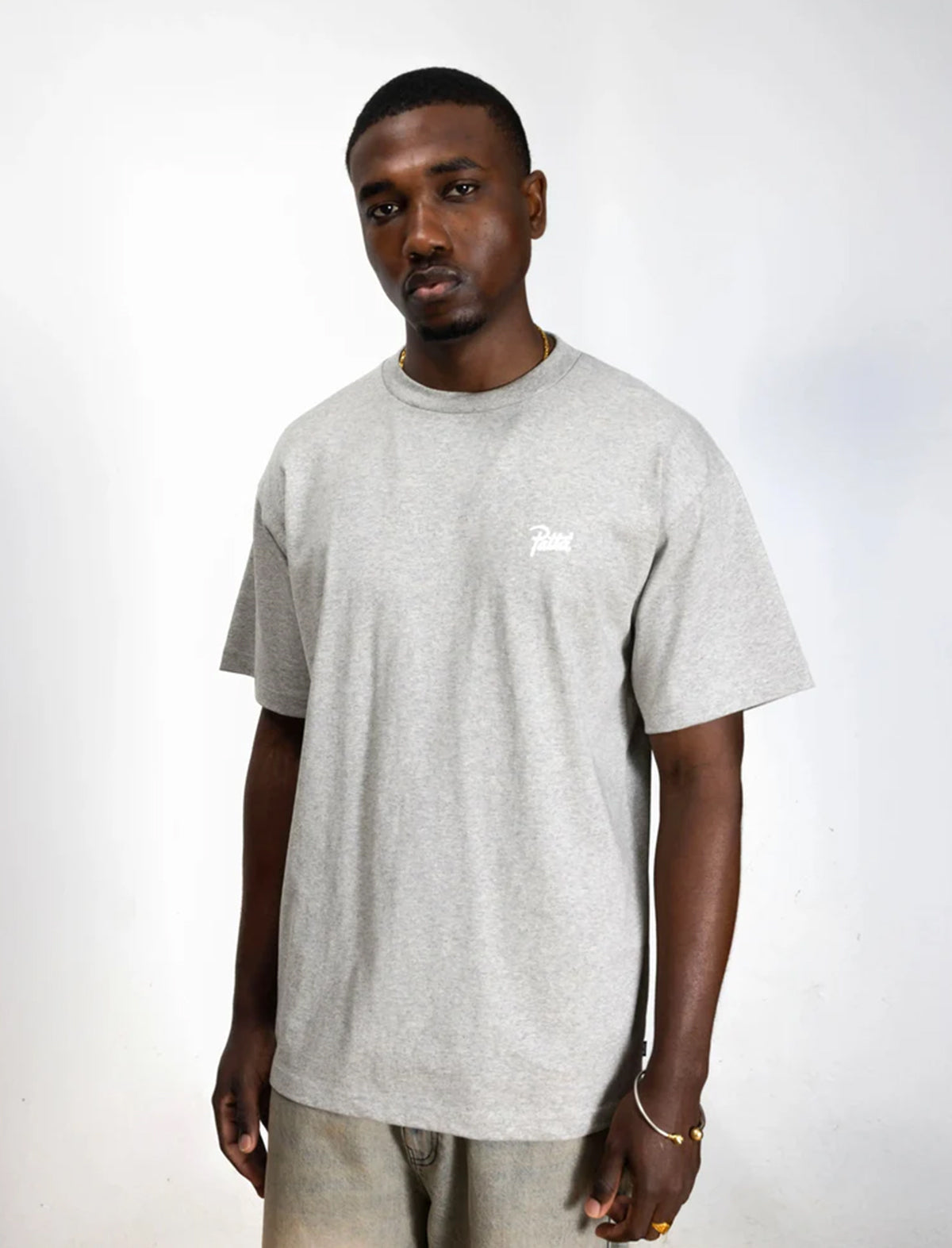 Man wearing a patta gray t-shirt with a small logo on a white background