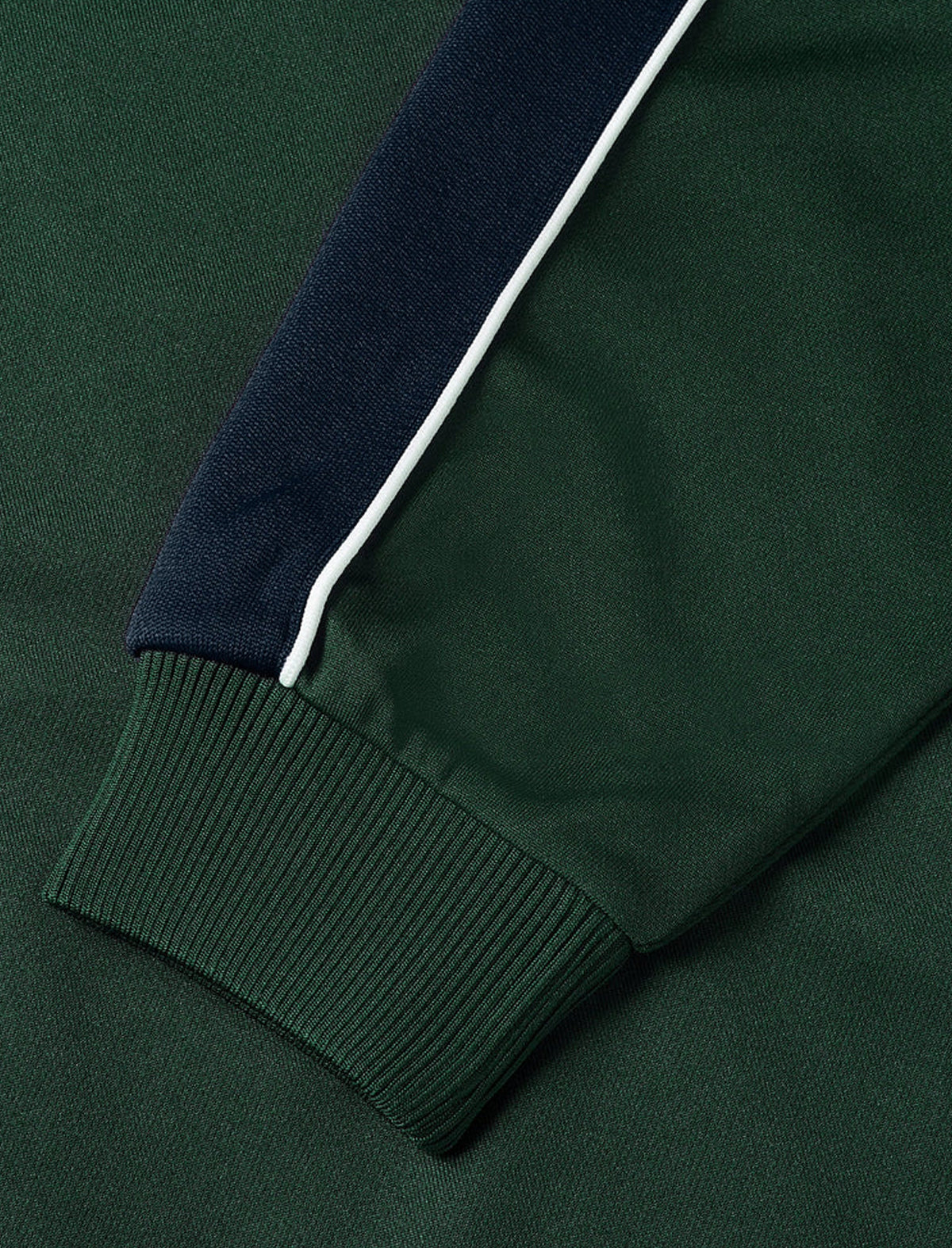 Close-up of a green jacket with navy and white trim on a matching green background