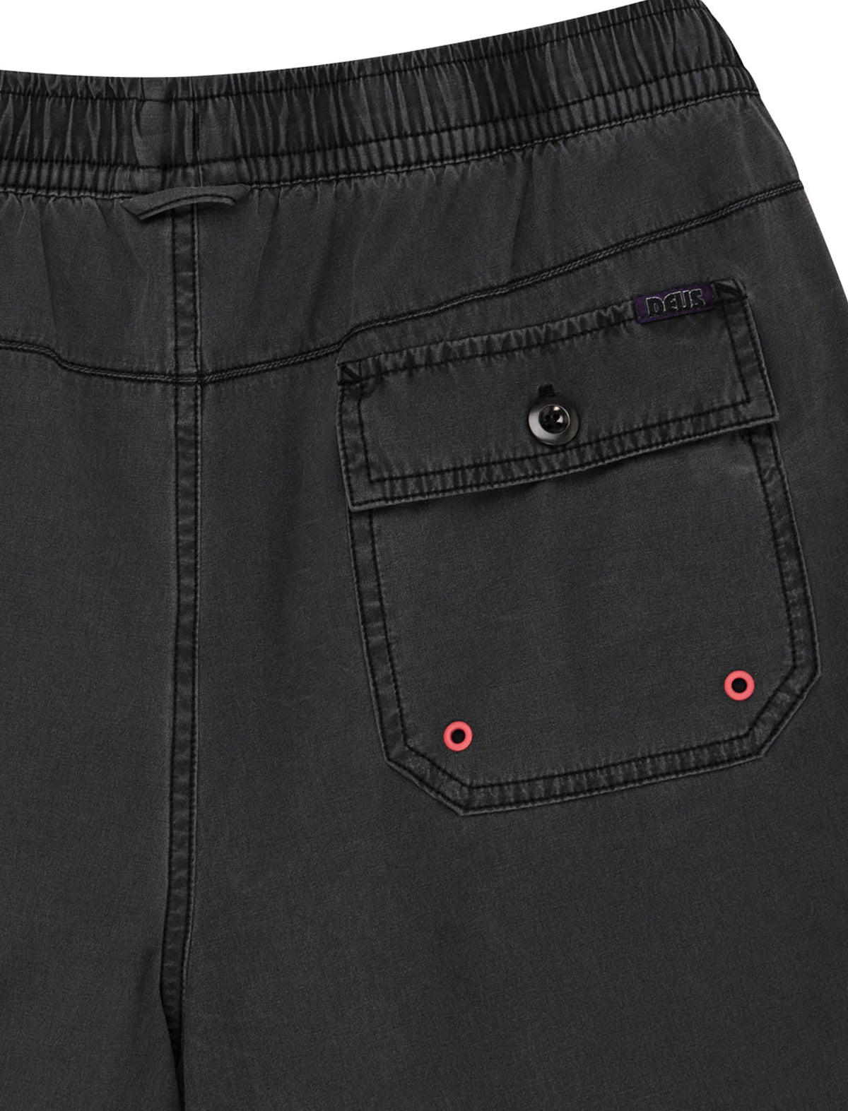 Close-up of black pants with a pocket and brand logo.
