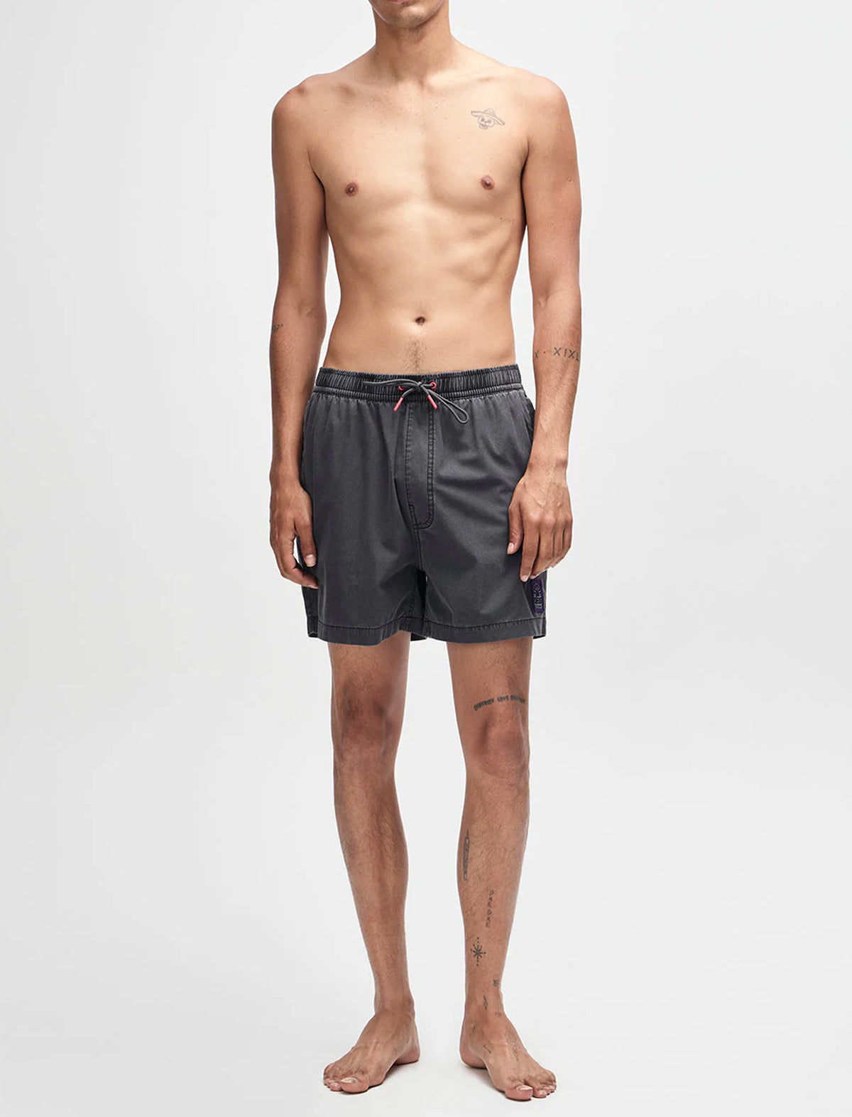 Man wearing dark gray swim shorts on a white background