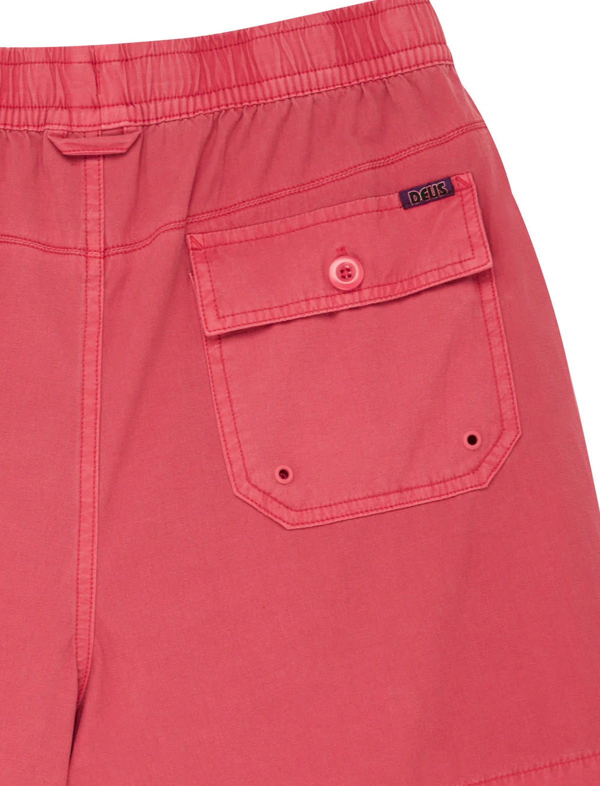 Close-up of a red pocket on shorts with a brand label.