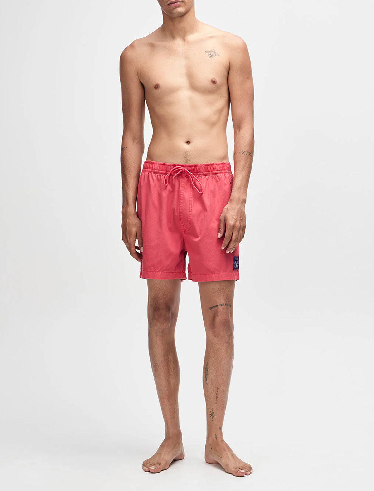 Man wearing pink swim shorts on a white background