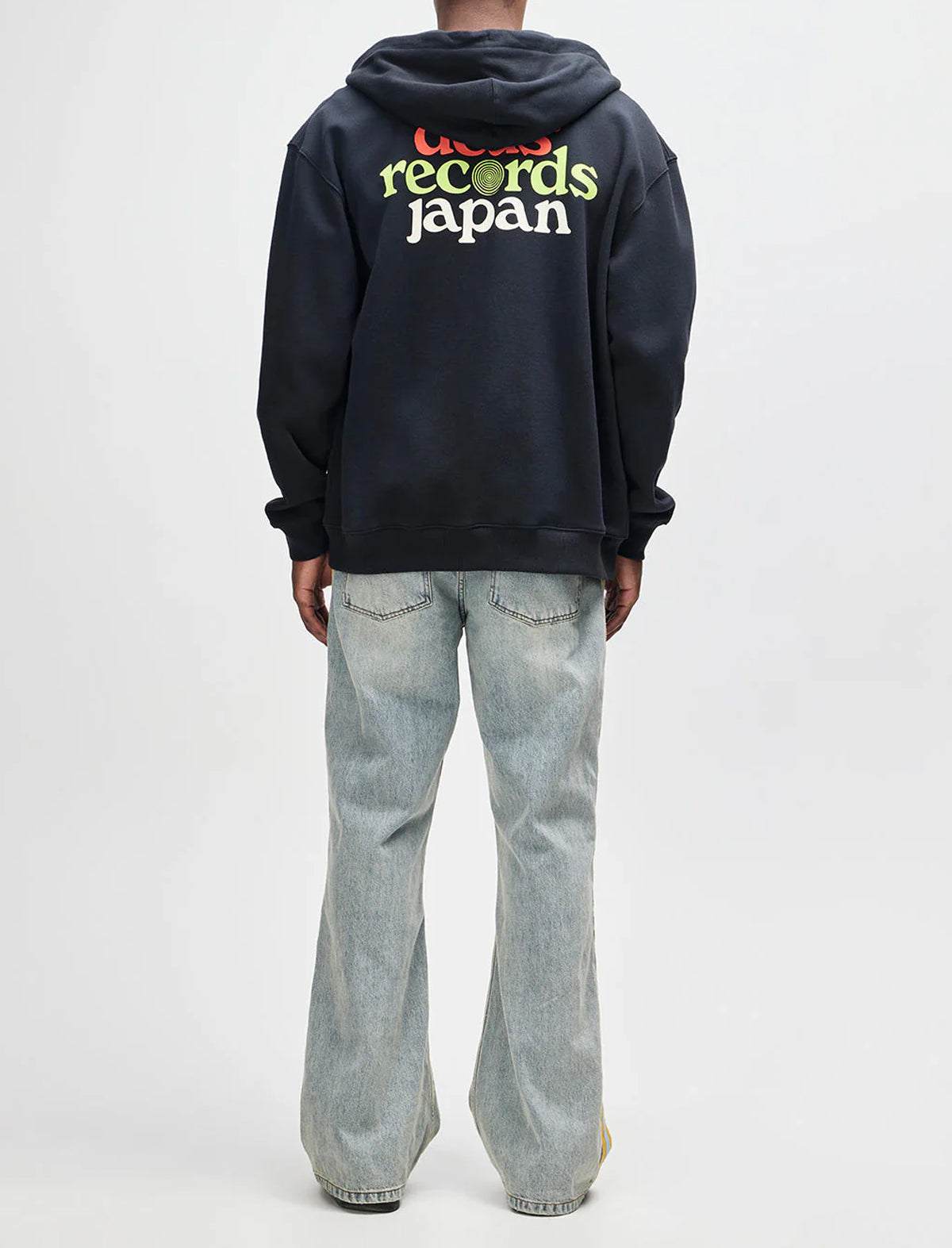 Person wearing a black hoodie with 'records Japan' text on the back, standing against a white background.