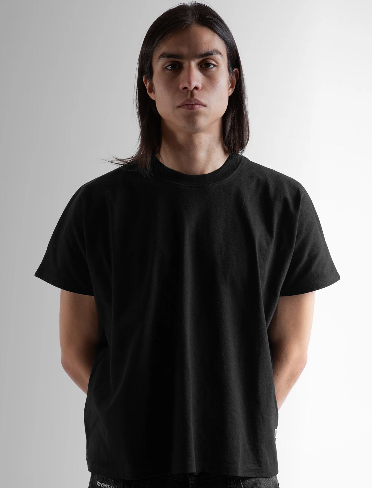 Person wearing a plain black t-shirt against a neutral background